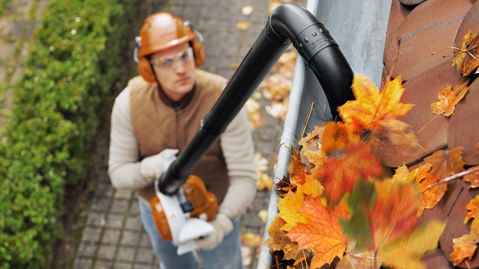Mand med STIHL BG 56 benzinbladblæser renser regnerende