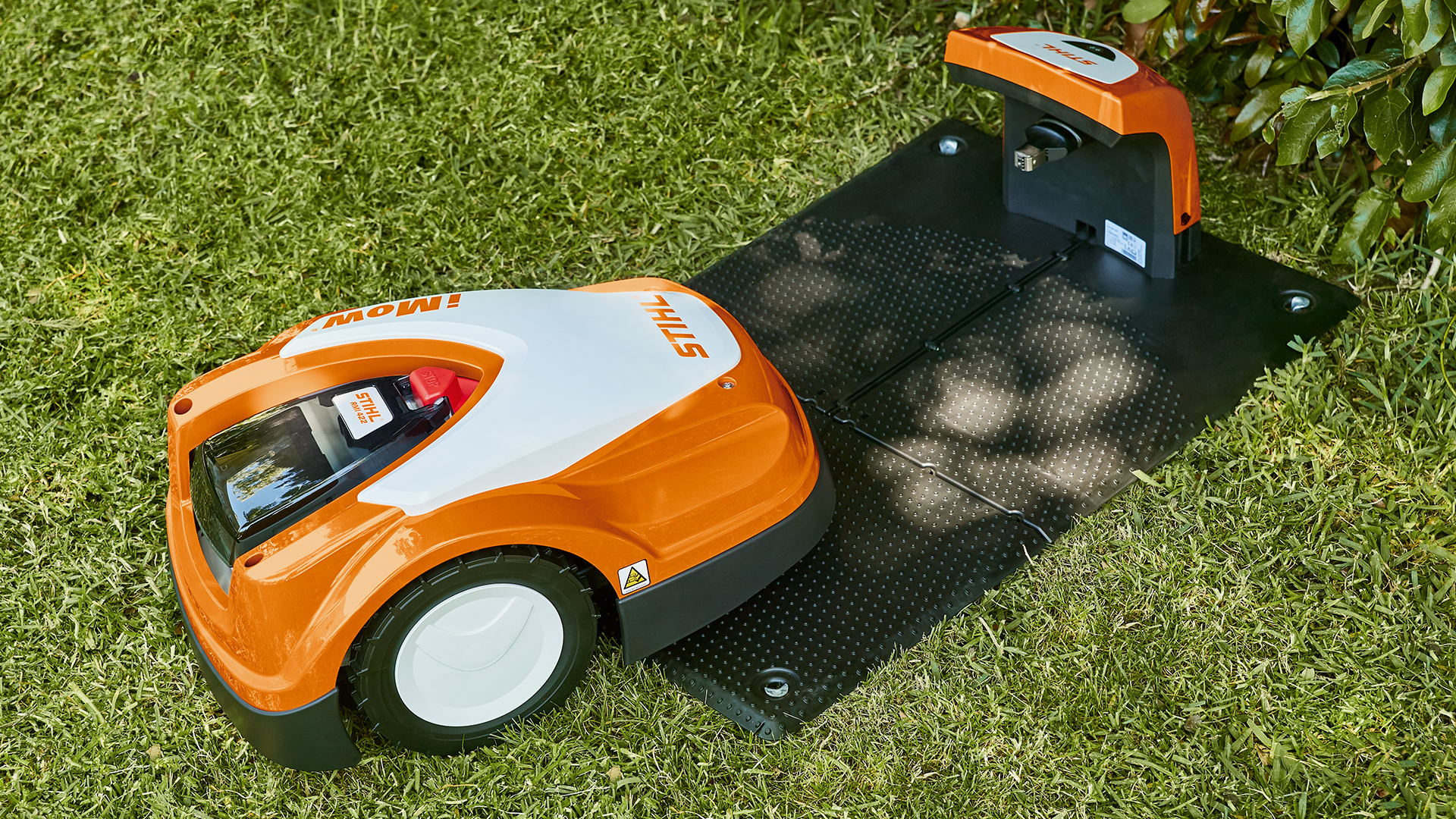 STIHL robotplæneklipper RMI 422 nærmer sig STIHL dockingstation i haven