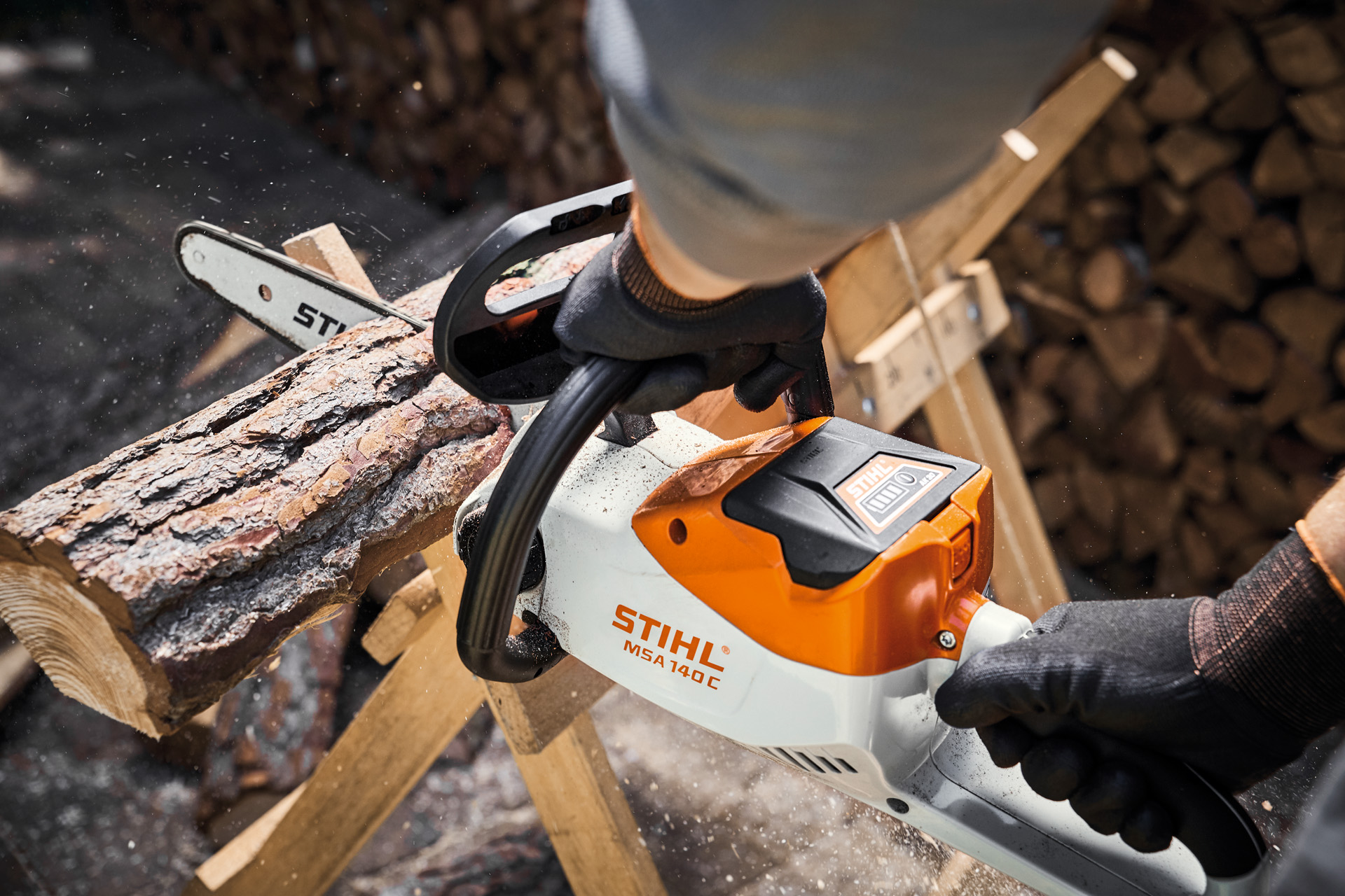Træstammen saves over med en STIHL motorsav