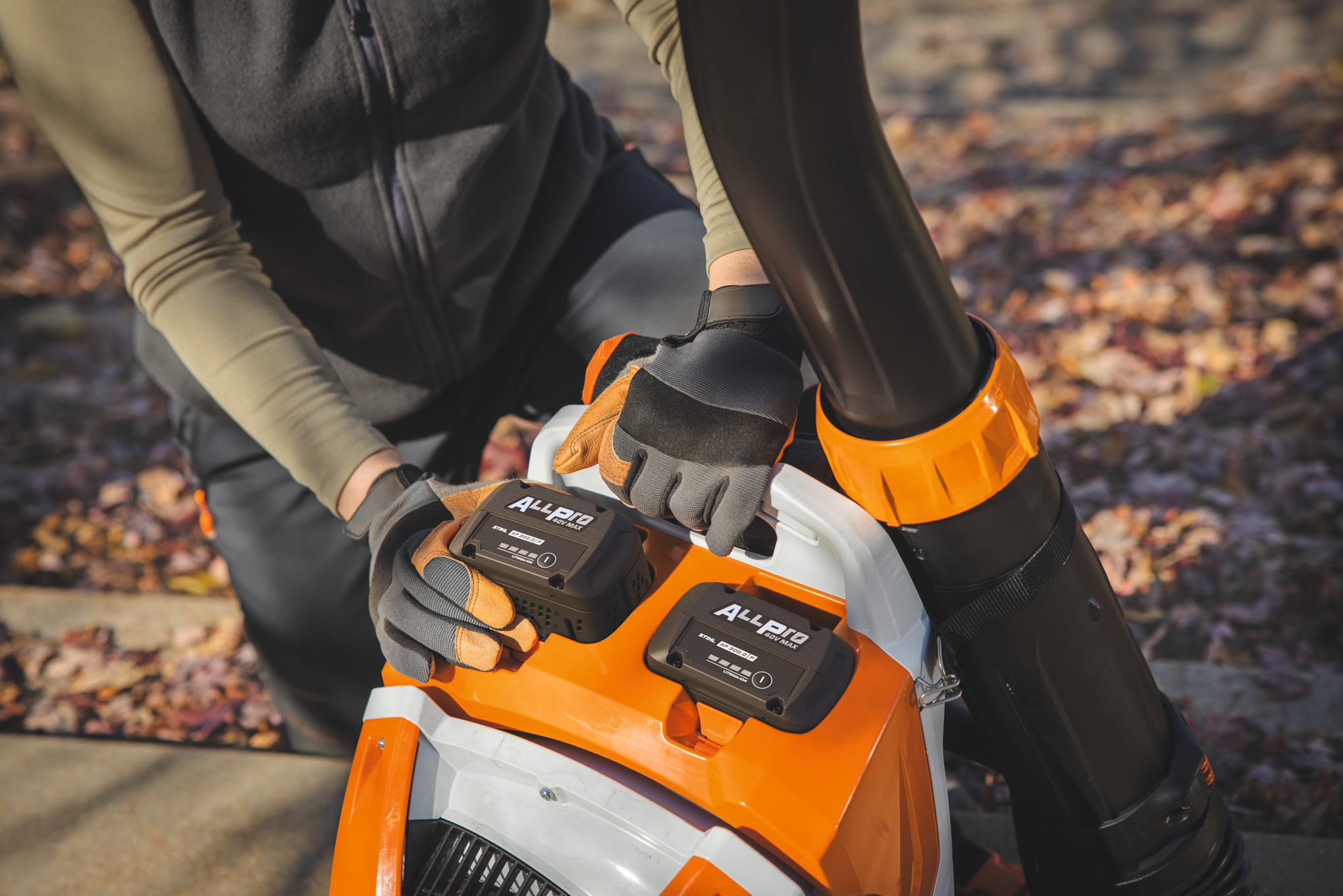 En professionel landskabsplejer sætter det andet STIHL batteri AP 300.0 P i STIHL batteri rygsæblæseren.