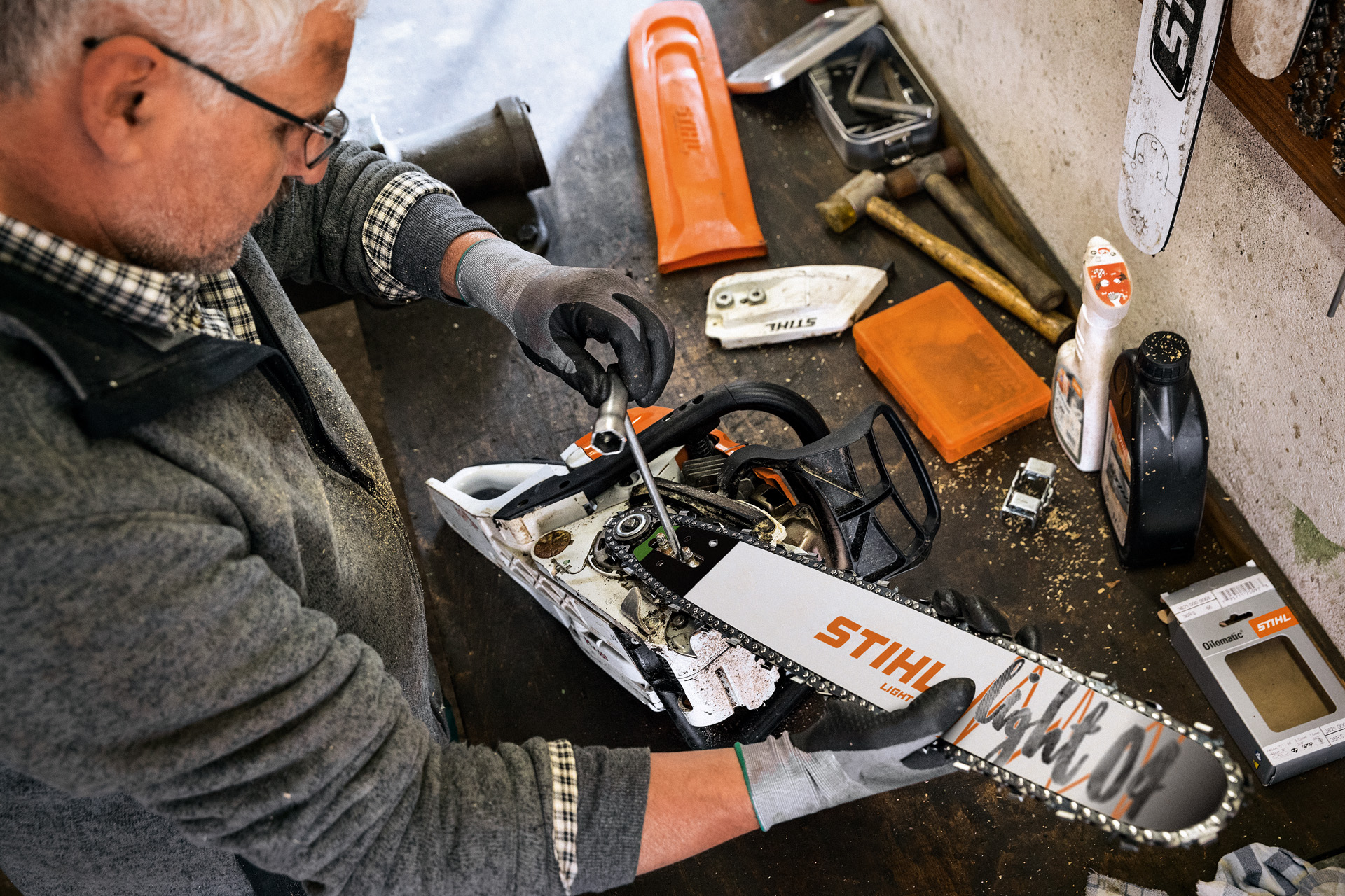 En STIHL-forhandler servicerer en motorsav med STIHL Light 04-sværd og Oilomatic-savkæde