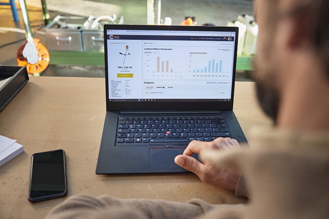 En person, der bruger STIHL connected-portalen på en bærbar computer for at se forskellige maskindata. 
