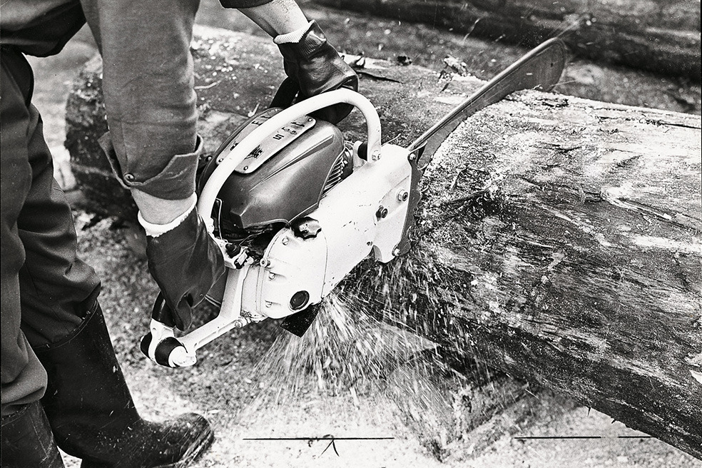 Gammelt sort-hvidt billede af en person, der fælder et træ med STIHL Contra-motorsaven 