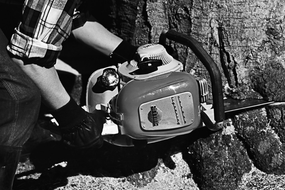 Gammelt sort-hvidt nærbillede af en person, der fælder et træ med STIHL Contra-motorsaven