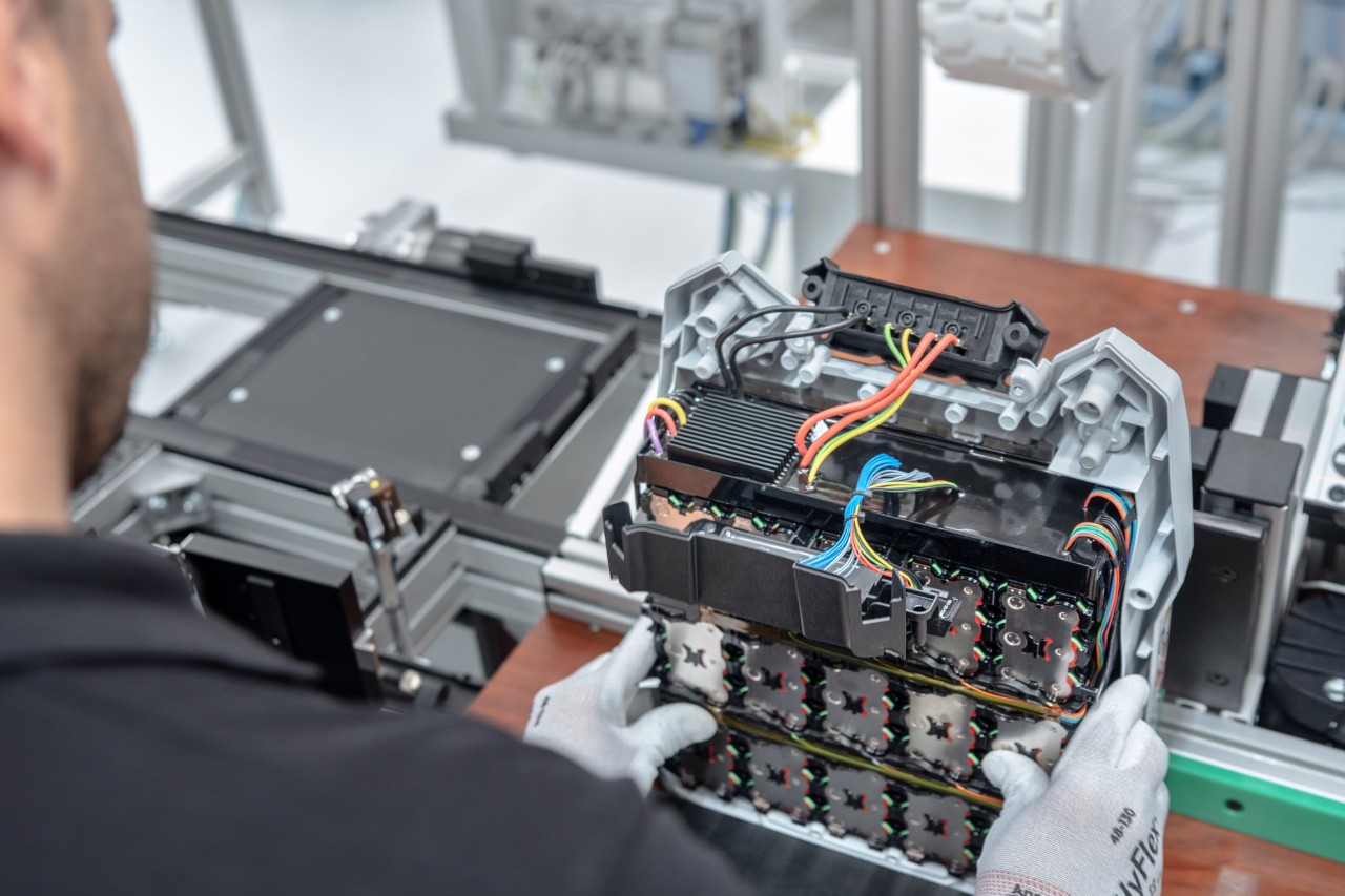 En mand, der holder et batteri til endelig samling