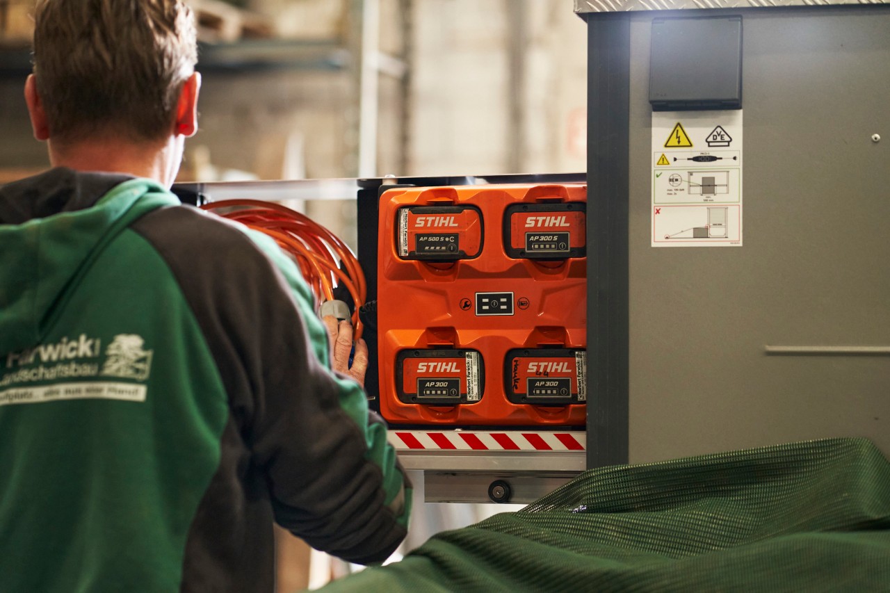 En medarbejder fra Farwick GmbH set bagfra står foran en bottTainer powered by STIHL