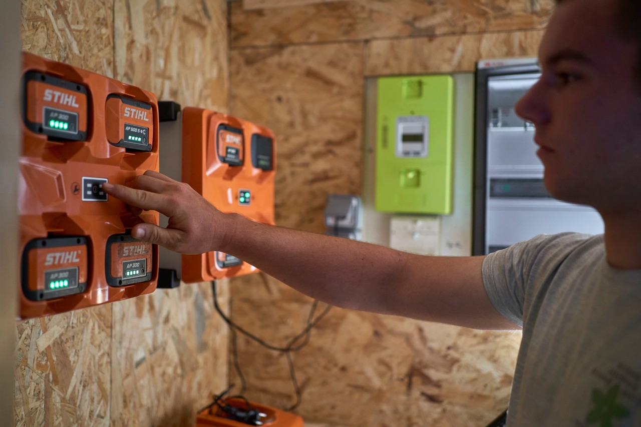 En mand står ved en batteriladestation
