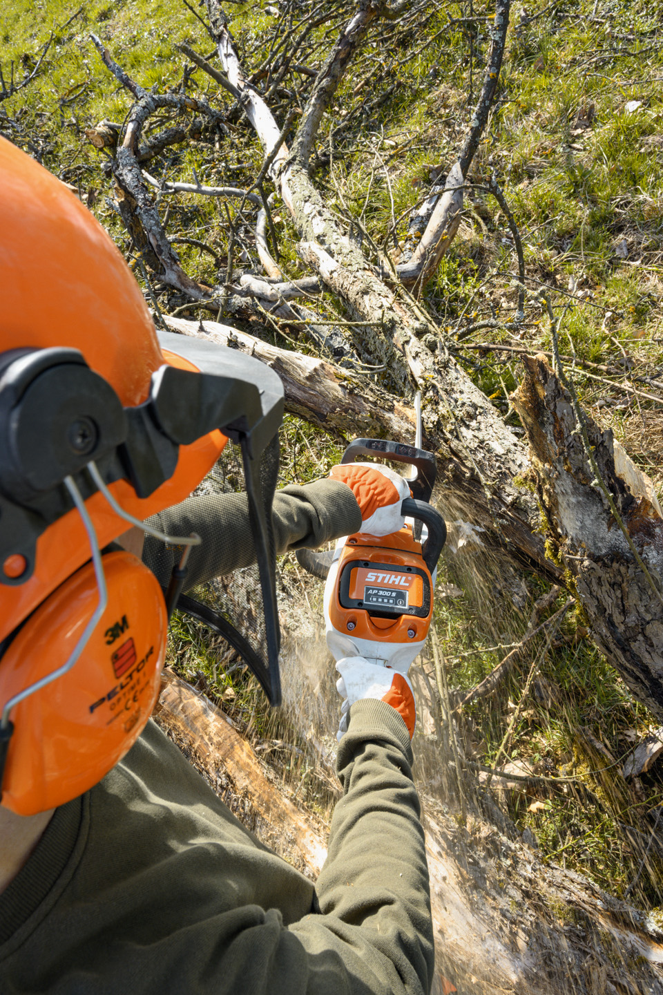 En STIHL MSA 220 C-B batteridrevet motorsav, der bruges til at fjerne grene fra en træstamme