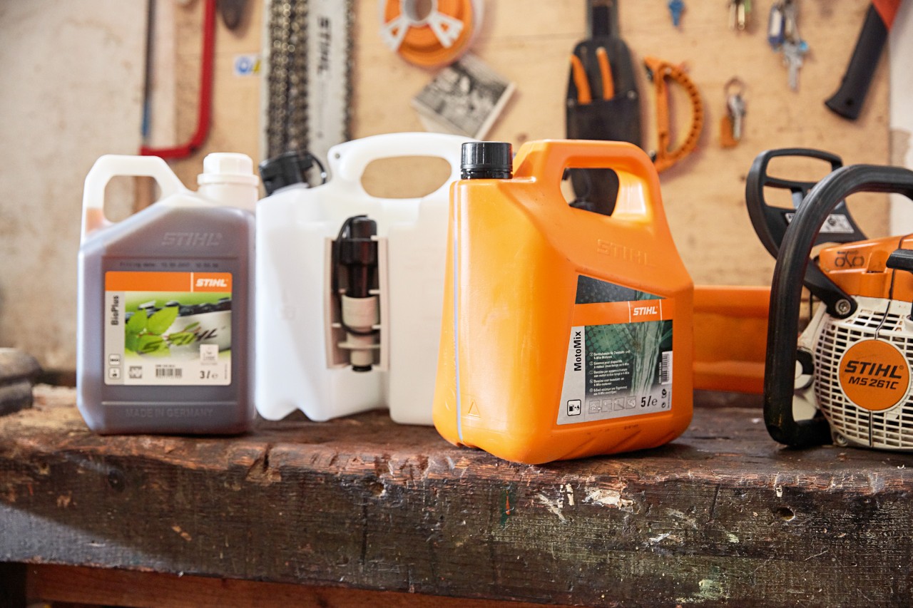 Dunk med STIHL MotoMix-motorsavsblanding, olie og benzin og en STIHL MS 261 C benzinmotorsav på et værksted