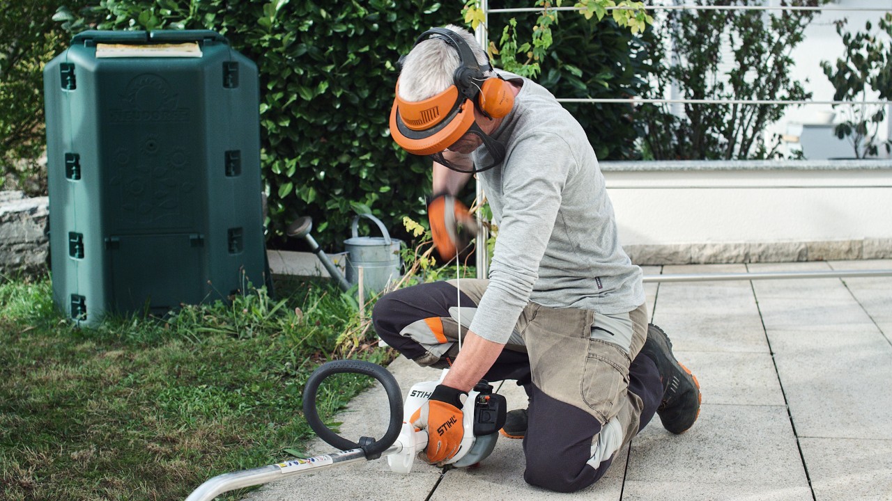 Person iført beskyttelsesbeklædning trækker i startsnoren på STIHL FS 38 benzindrevet buskrydder