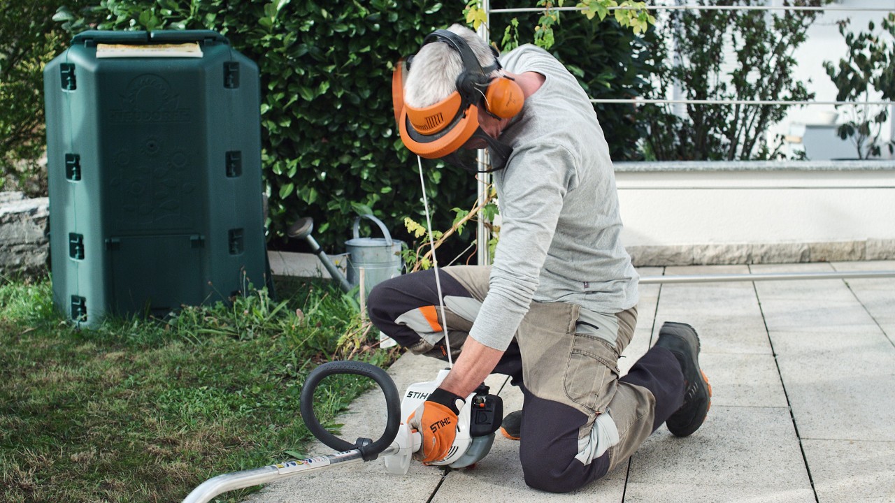 Person iført beskyttelsesbeklædning trækker i startsnoren til STIHL FS 38 benzindrevet buskrydder igen
