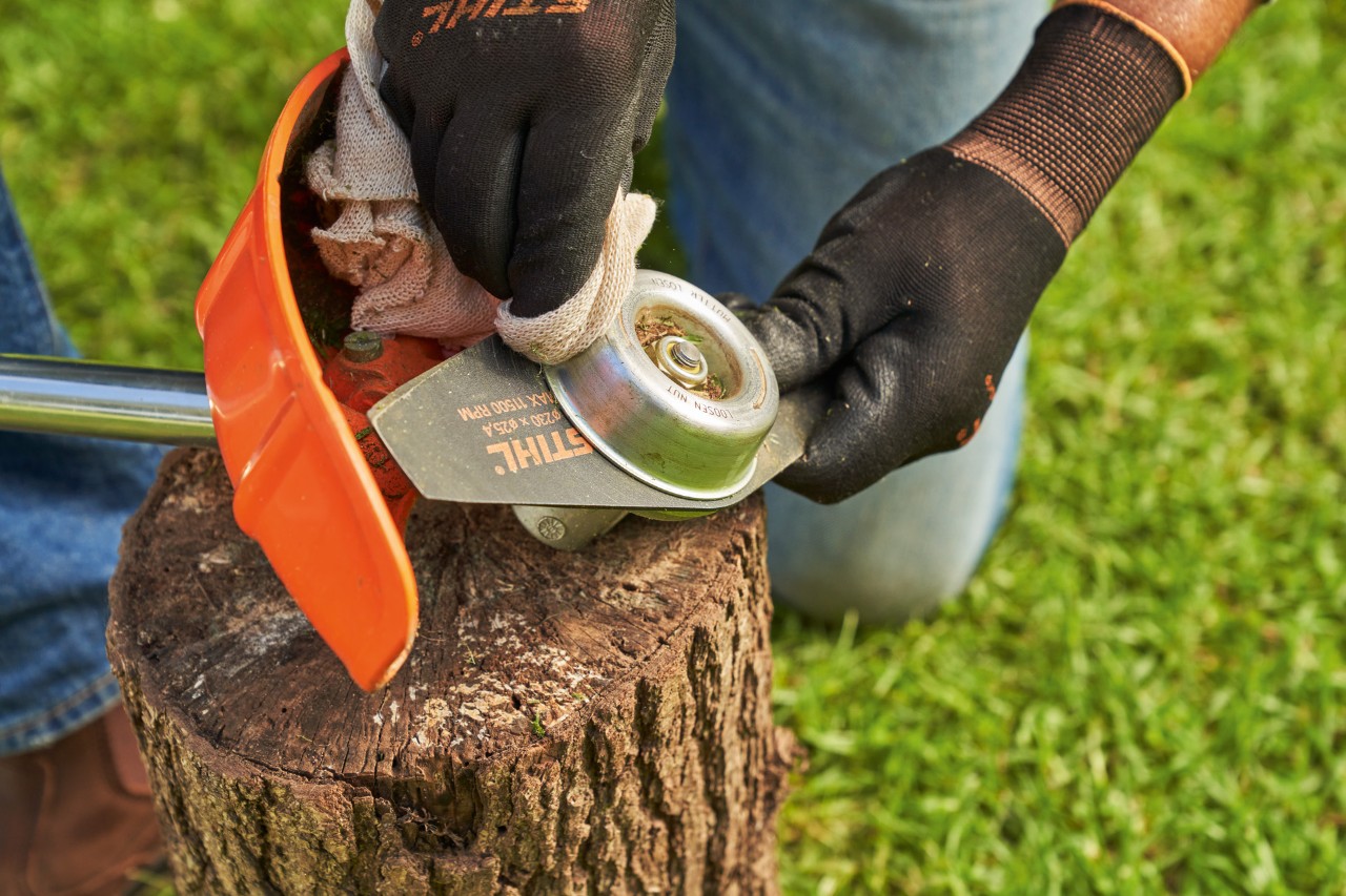 Rengøring af en kniv på STIHL buskrydder med en fugtig klud