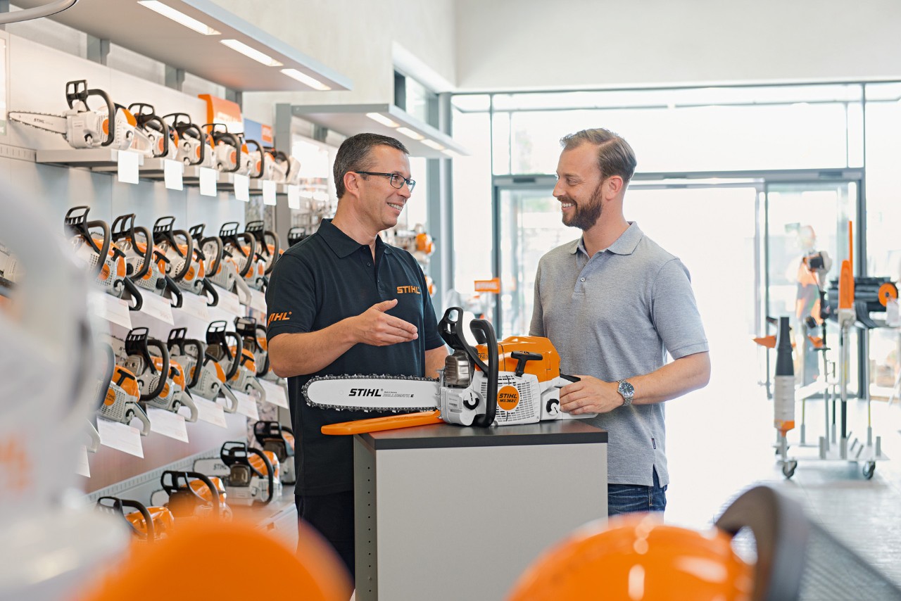 En STIHL-forhandler hjælper en kunde med at købe en STIHL-motorsav.