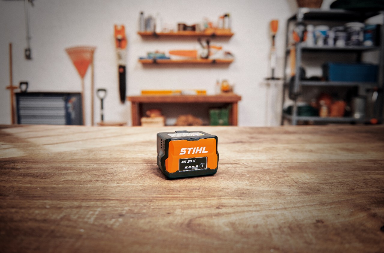 Værksted med et STIHL AK 30 S-batteri på et træbord 