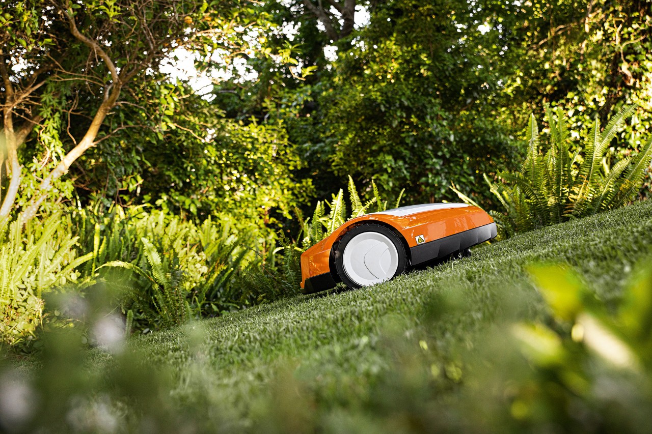 En STIHL iMOW® RMI 632 robotplæneklipper på en bakket græsplæne 