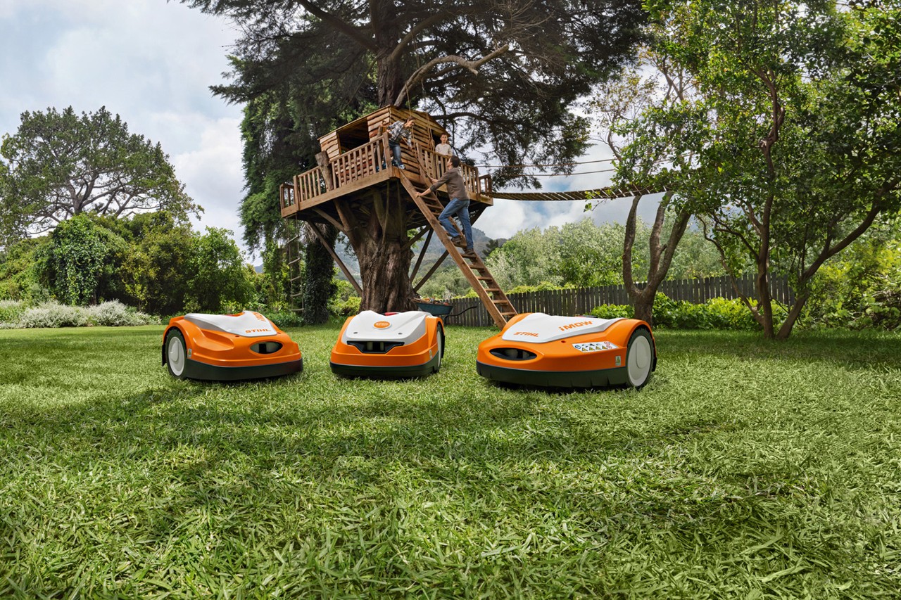 STIHL iMOW®-robotplæneklipperserien på en grøn plæne i haven